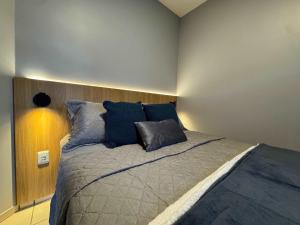 a bedroom with a large bed with blue pillows at Studio Unimorada Near Lake Shopping and Market in Toledo