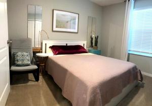 a bedroom with a large bed and a chair at NEW Home 3 Bedrooms Water View Disney Universal in Kissimmee +28 photos