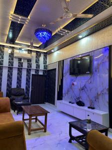 a living room with a tv and a table at Sky Rooms & Cafe in Mughal Sarāi +11 photos