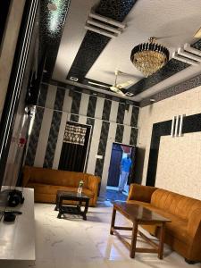 a living room with couches and a table and a person at Sky Rooms & Cafe in Mughal Sarāi