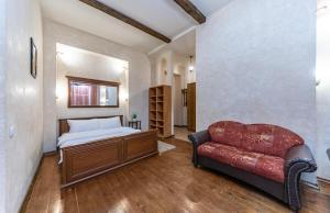 a bedroom with a bed and a red couch at Baroque-Style Apartment in the Heart of Kyiv in Kyiv