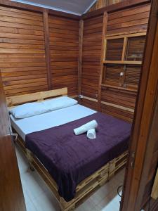 a bedroom with a bed with two towels on it at Chalé frente para o lago - Camping Carrion in Itu +13 photos