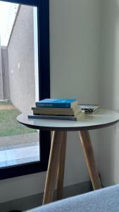 un montón de libros sentados en una mesa junto a una ventana en Casa em Redenção próx à Pecuária, en Redenção