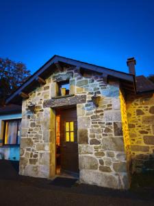 a stone house with a door at night at Maison de charme à la Salvetat-sur-Agout 3 chambres in La Salvetat