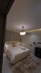 a bedroom with a large white bed and a chandelier at سكاي لاين سويت in Jeddah +5 photos