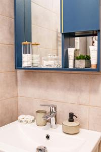 a bathroom sink with a blue cabinet above it at AMBER Studio in Craiova +53 photos