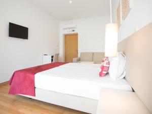 a bedroom with a white bed with a red blanket at Tavira Monte in Tavira