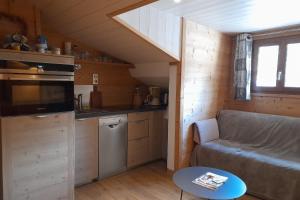 - un salon avec un canapé dans une petite maison dans l'établissement Apartment in the center of the village, à La Clusaz