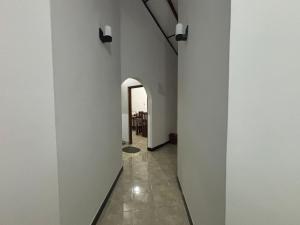 a hallway of a house with white walls and an archway at Solara Holiday Homes in Anuradhapura