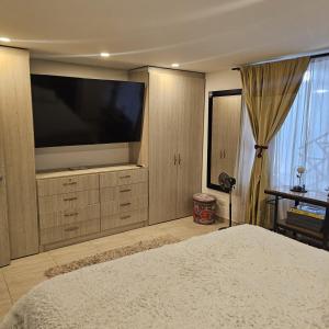 a bedroom with a large television and a bed at Restrepo 201 in Bogotá