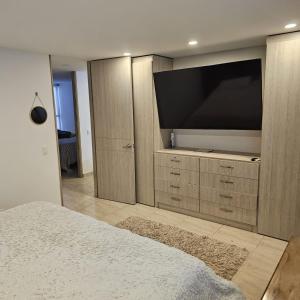 a bedroom with a large flat screen tv on a cabinet at Restrepo 201 in Bogotá