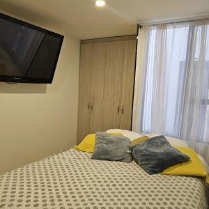 a bedroom with a bed with two pillows on it at Restrepo 201 in Bogotá +4 photos