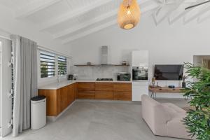 a white kitchen with a couch and a table at Villa Flair in Jan Thiel