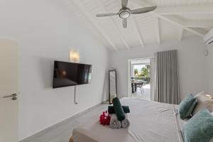 a white room with a bed and a ceiling fan at Villa Flair in Jan Thiel