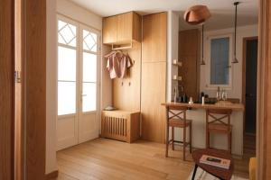 eine Küche mit Holzschränken und einer Tür und einem Tisch in der Unterkunft Dandy Downtown Apt in Budapest