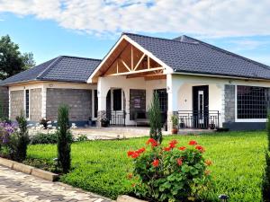 une maison avec une cour verdoyante ornée de fleurs dans l'établissement Nelle's Place, à Eldoret