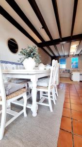 a dining room with a white table and chairs at Villa Blue beach Tabarca in Tabarca