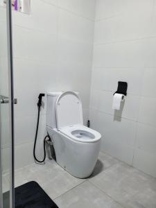 La salle de bains est pourvue de toilettes blanches avec un tuyau. dans l'établissement Nelle's Place, à Eldoret 15 autres photos