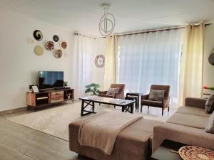 un salon avec un canapé et une télévision dans l'établissement Nelle's Place, à Eldoret