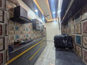 a room with a kitchen with a counter and a stove at 2BHK Home fully furnished at Sahid Nagar near INOX in Bhubaneshwar