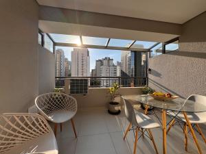einen Balkon mit einem Tisch und Stühlen sowie Stadtblick in der Unterkunft Flat em Moema Grand Vitrali - Aero Congonhas in São Paulo