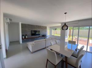 Una sala de estar con un sofá, una mesa y sillas. en Buzios Heven, en Búzios