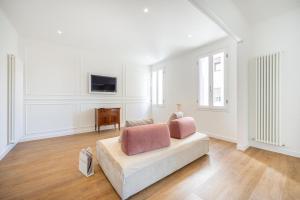 a white living room with a couch and a television at Lodge 46 Luxury Apartment in Venice