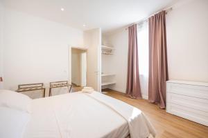 a white bedroom with a bed and a window at Lodge 46 Luxury Apartment in Venice