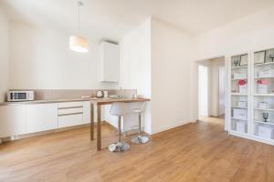 a kitchen with white cabinets and a table in it at Lodge 46 Luxury Apartment in Venice +10 photos
