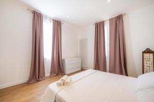 a bedroom with a white bed with two white shoes at Lodge 46 Luxury Apartment in Marghera