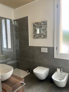 a bathroom with a toilet and a sink and a mirror at Lodge 46 Luxury Apartment in Venice