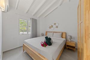 a bedroom with a white bed with flowers on it at Villa Flair in Jan Thiel +12 photos