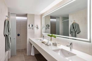 a bathroom with two sinks and a large mirror at Avani Cancun Airport in Cancún