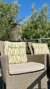 a wicker chair with two pillows on a patio at Horizonte da Vinha in Santo Tirso