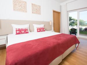 um quarto com uma cama grande e um cobertor vermelho em Tavira Monte em Tavira