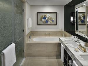 La salle de bains est pourvue d'une baignoire et de 2 lavabos. dans l'établissement Grand Plaza Mövenpick Media City, à Dubaï