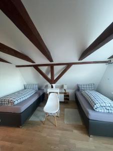 2 bedden in een kamer met houten plafonds bij See Igel Sjöborre in Wismar