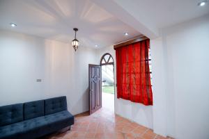 a living room with a couch and a red curtain at Bungalow Salvaxia in Chichicastenango