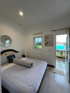 a bedroom with a large white bed and a window at Passion Nai Harn Guesthouse in Nai Harn Beach +29 photos
