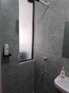 y baño con ducha, ventana y lavamanos. en The Nook cozy stays, en Kiambu