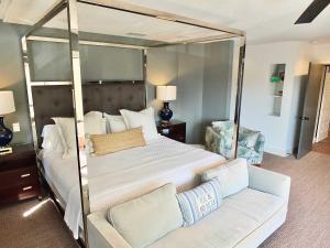 a bedroom with a canopy bed and a couch at Naples Luxury Retreat - 2 BDR Walk to Beach Dining & Shops in Naples