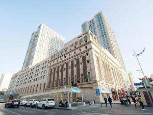 Un gran edificio con coches aparcados delante. en Mercure Harbin Central Street Sophia Church, en Harbin