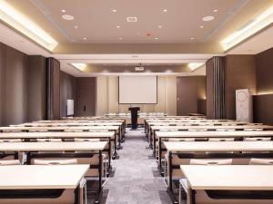 an empty lecture room with tables and a whiteboard at Mercure Harbin Central Street Sophia Church in Harbin
