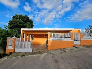 a orange house with white gates on a street at Magnificent accommodation in Puerto Plata
