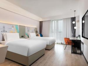 a hotel room with two beds and a desk at Mercure Chengdu Xindu in Chengdu