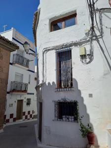 a white building with a window and a gate at El Cap de Pedra in Calles