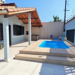 a swimming pool in the backyard of a house at Casa de Praia - Pe na Areia in Mongaguá