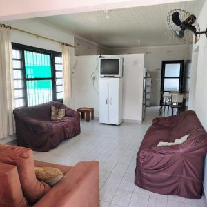 a living room with two couches and a refrigerator at Casa de Praia - Pe na Areia in Mongaguá