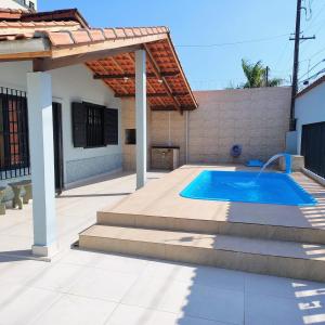 a swimming pool in the backyard of a house at Casa de Praia - Pe na Areia in Mongaguá