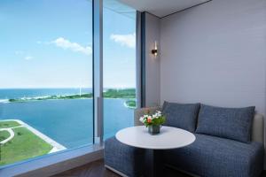 a living room with a couch and a table with flowers at Crowne Plaza Weihai Binhai by IHG in Weihai